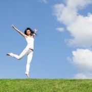 vrouw springt in gras shutterstock_67254202